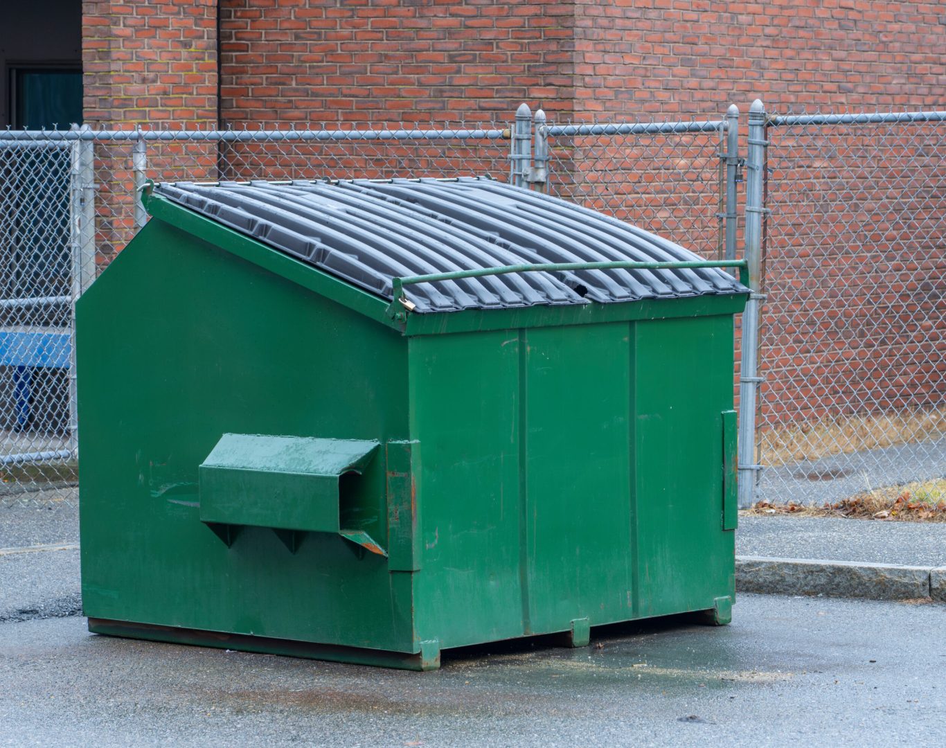large green commercial dumpster for trash and recycling